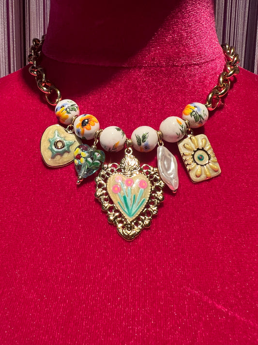 Collana girocollo dorata con perle disegni floreali , cuore sacro smaltato e charms