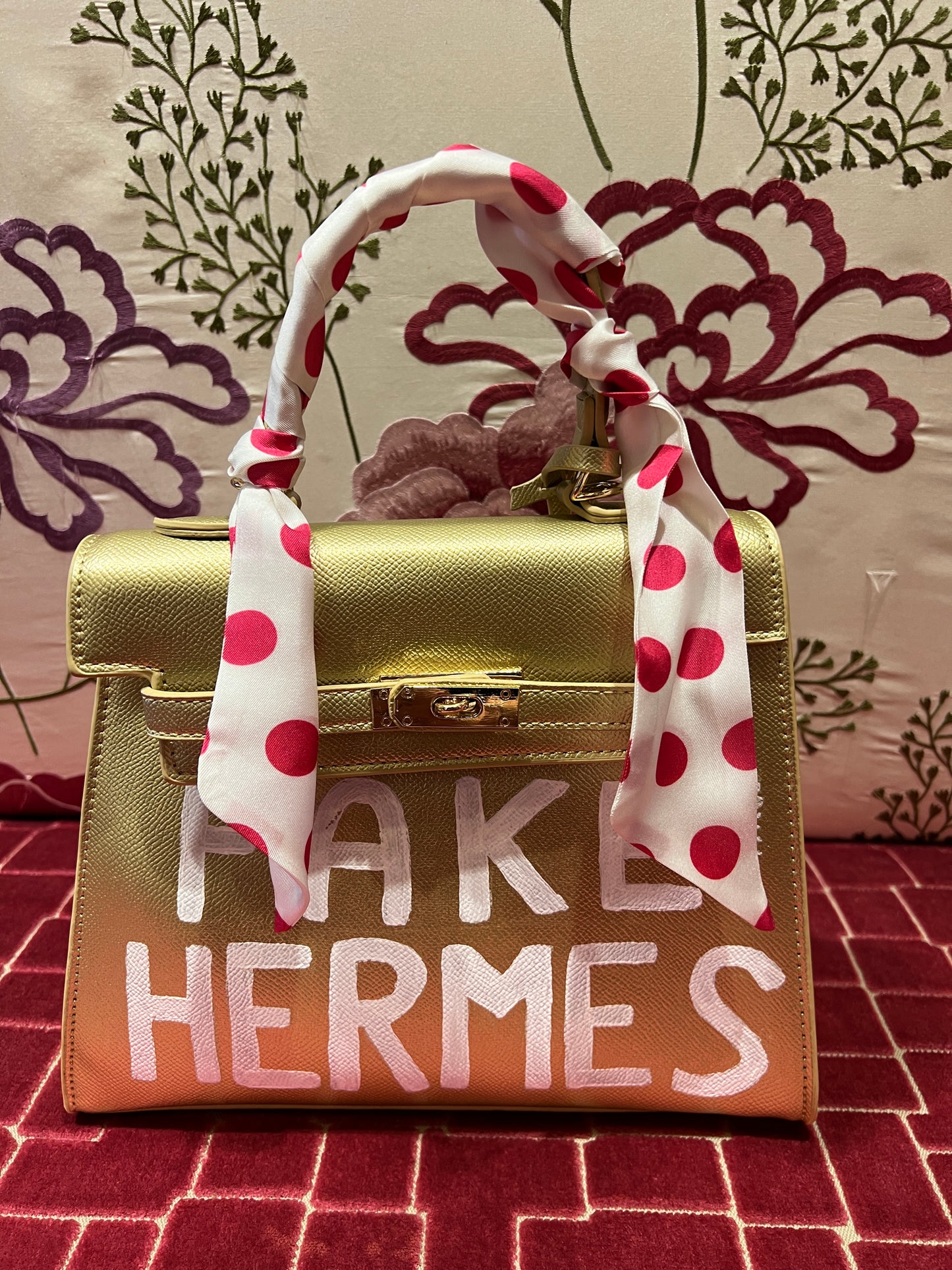 Borsa oro dipinta a mano con scritta “ Fake Hermes “ bianca con tracollina
