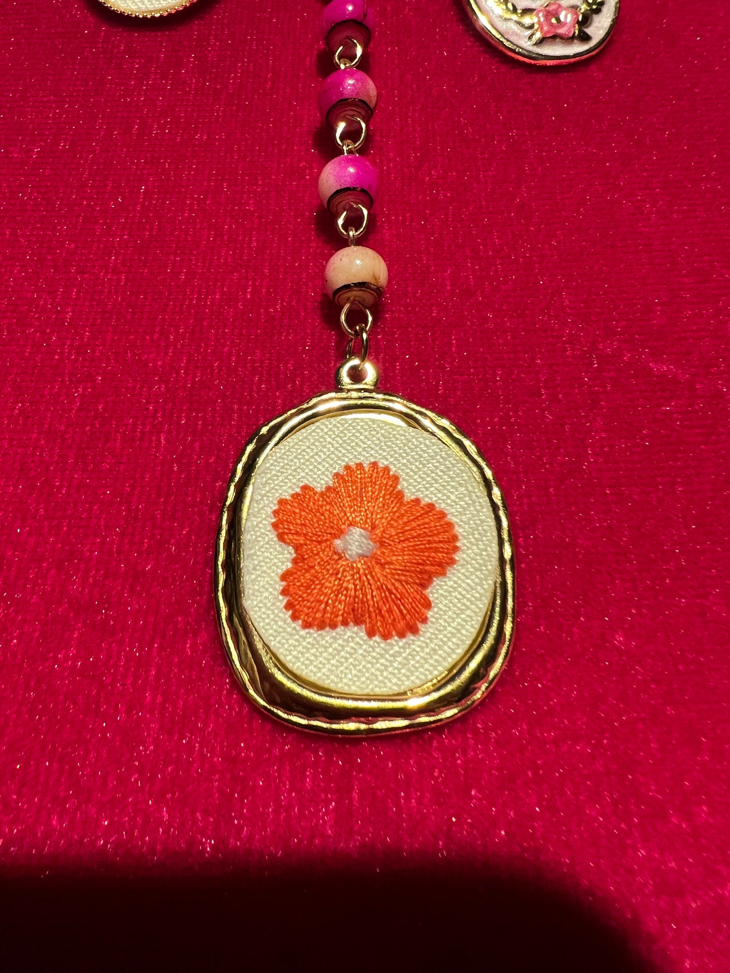 Collana con perline fucsia montatura a rosario con ciondolo fiore ricamato e charms