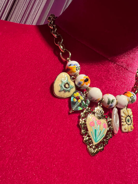 Collana girocollo dorata con perle disegni floreali , cuore sacro smaltato e charms