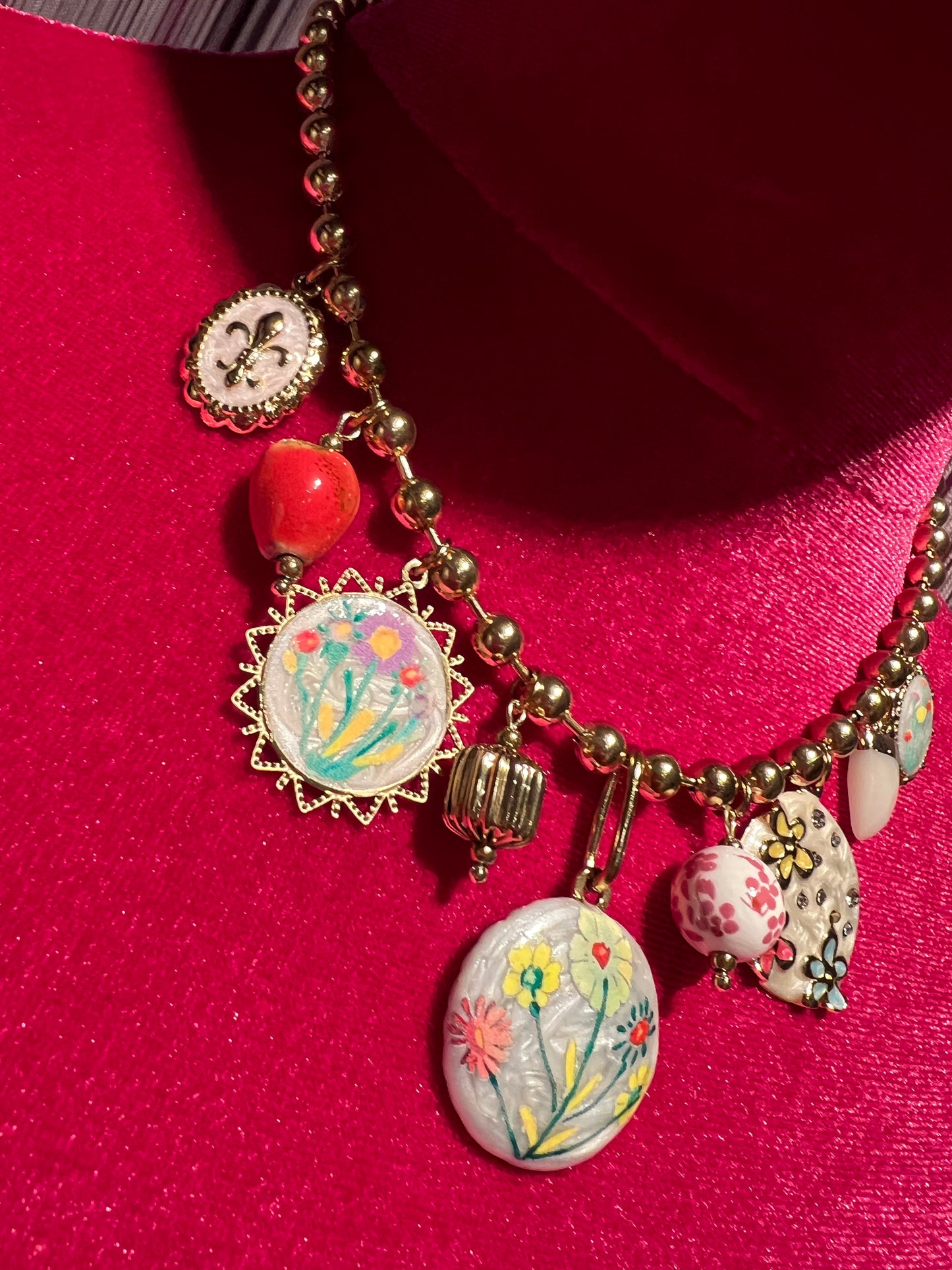 Collana girocollo con palline dorate charms floreali su base bianca