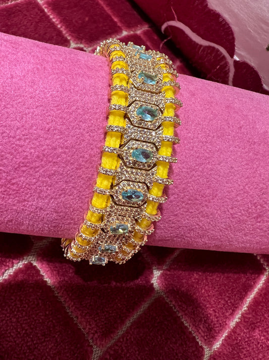 Bracciale regolabile in pavé di cristalli e pietre celesti montato su cordoncino giallo