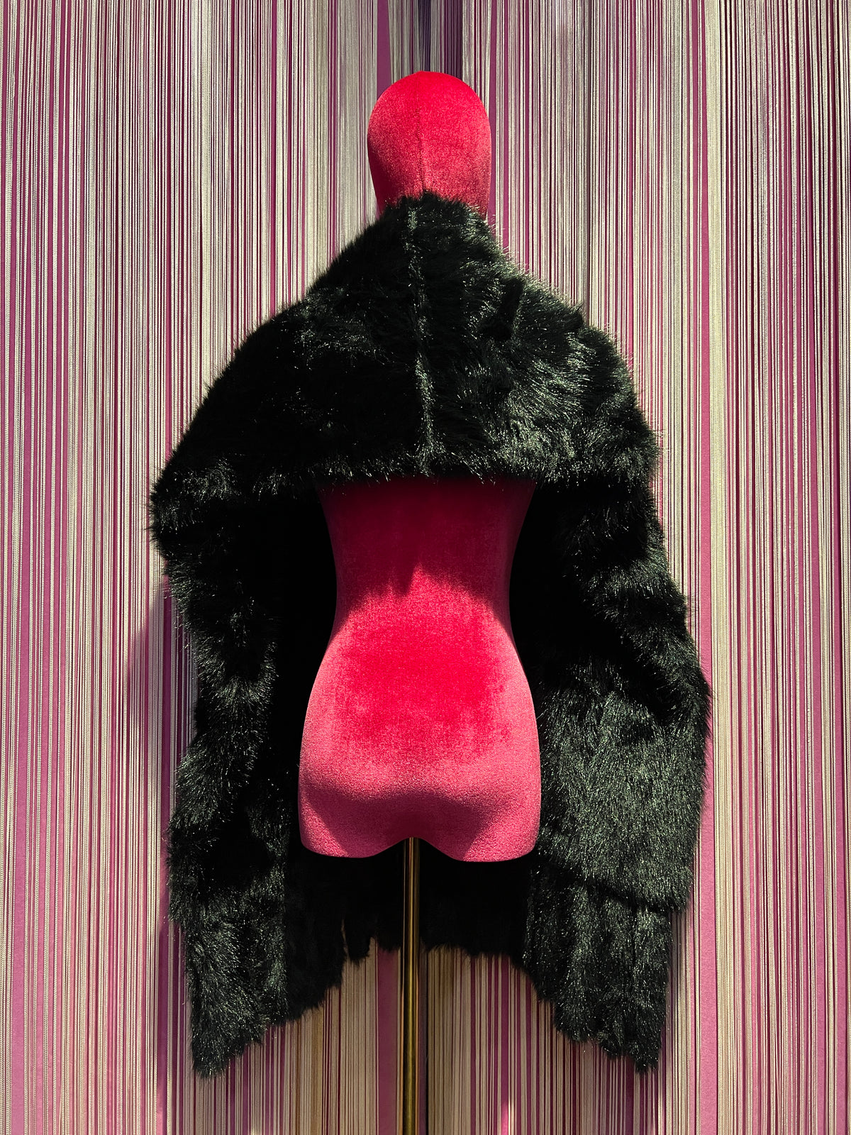 The room cappa nera in simil pelliccia con tasche e frange