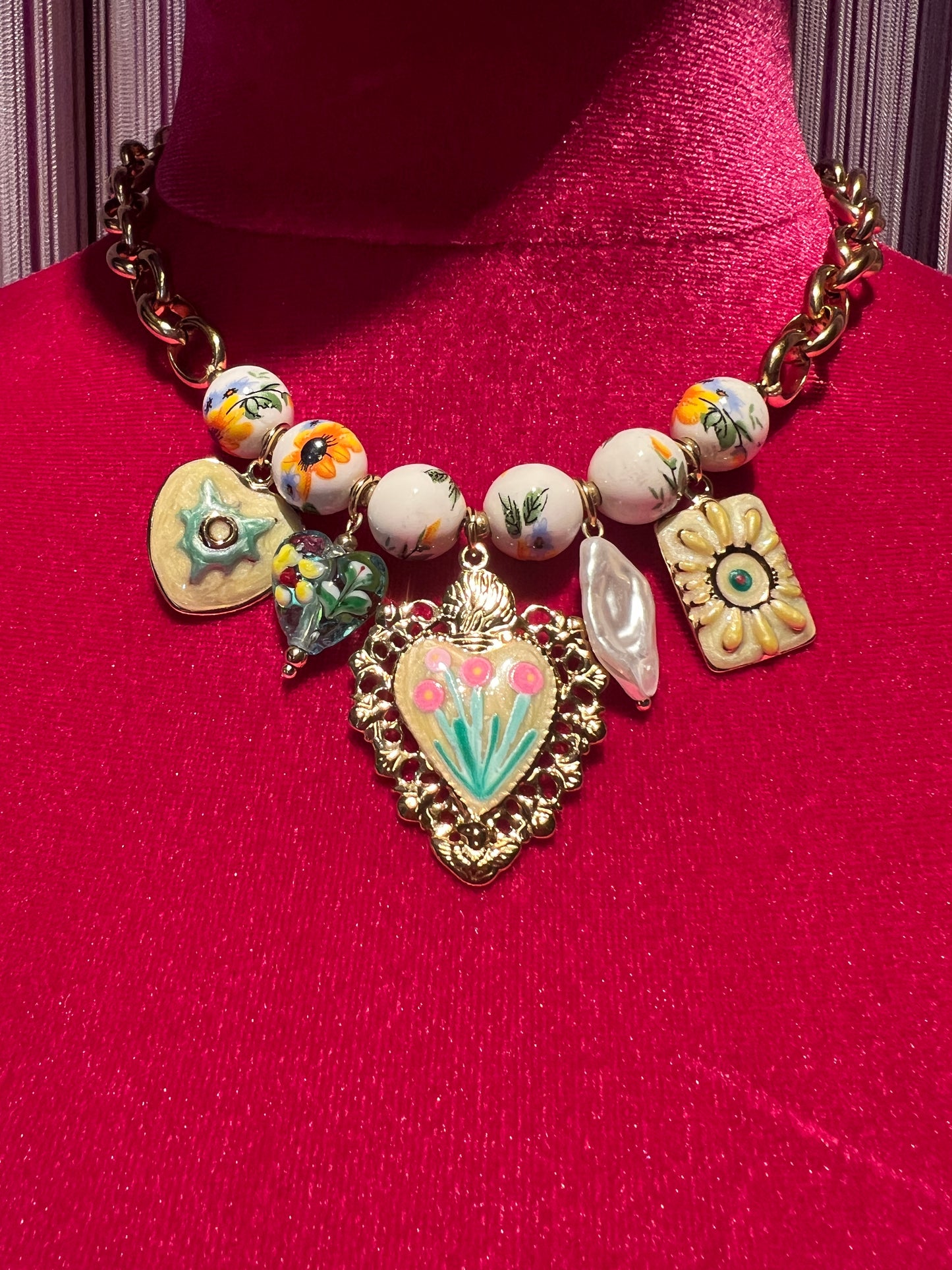 Collana girocollo dorata con perle disegni floreali , cuore sacro smaltato e charms