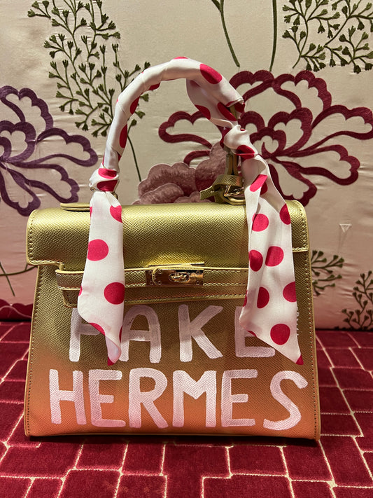 Borsa oro dipinta a mano con scritta  “ Fake Hermes “ bianca con tracollina