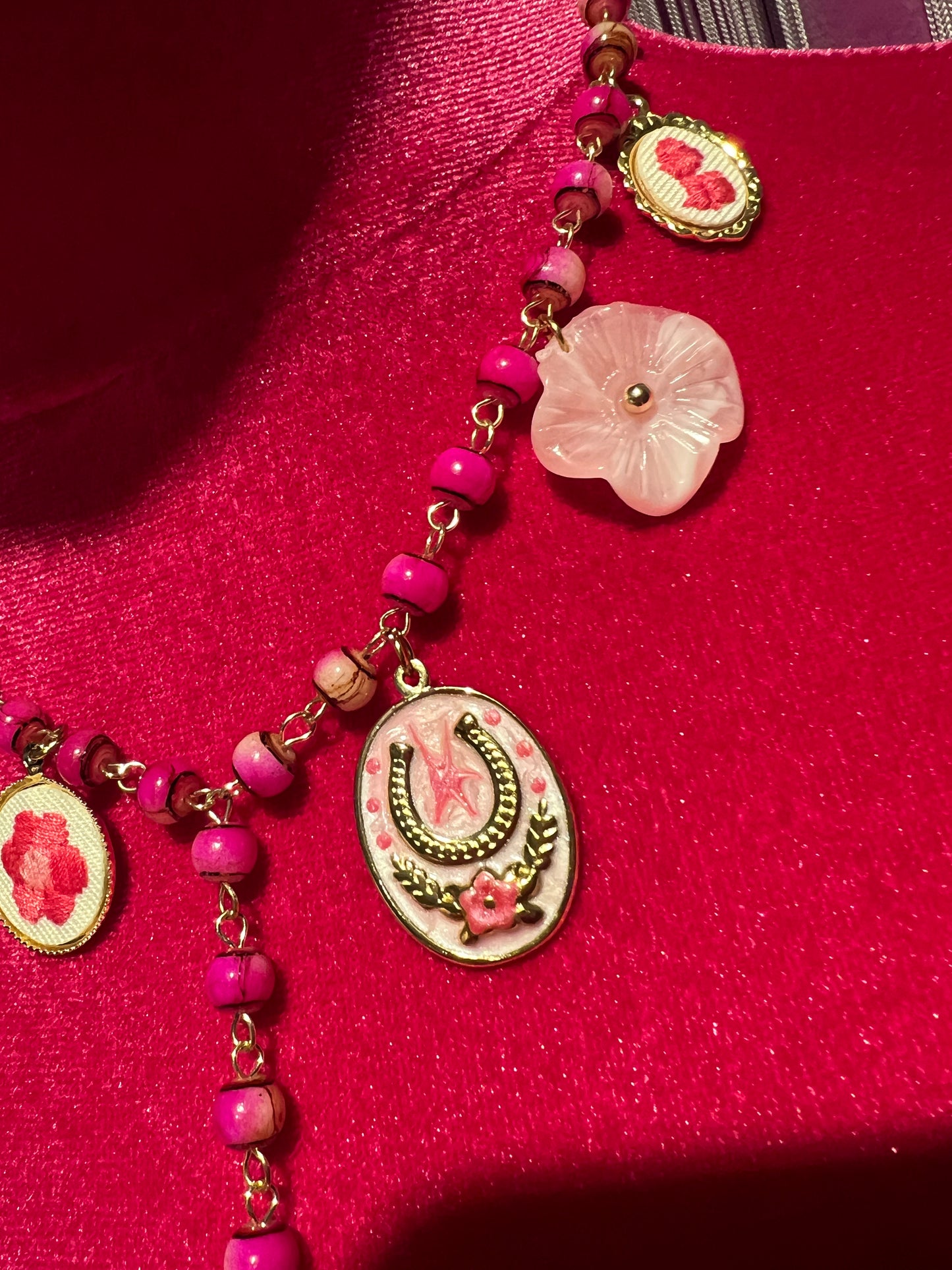 Collana con perline fucsia montatura a rosario con ciondolo fiore ricamato e charms
