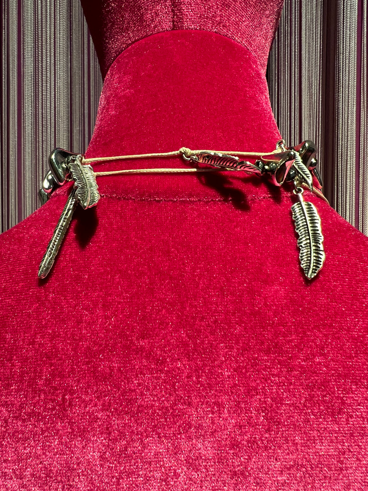 Collana con cordino , elementi color argento e charms piume