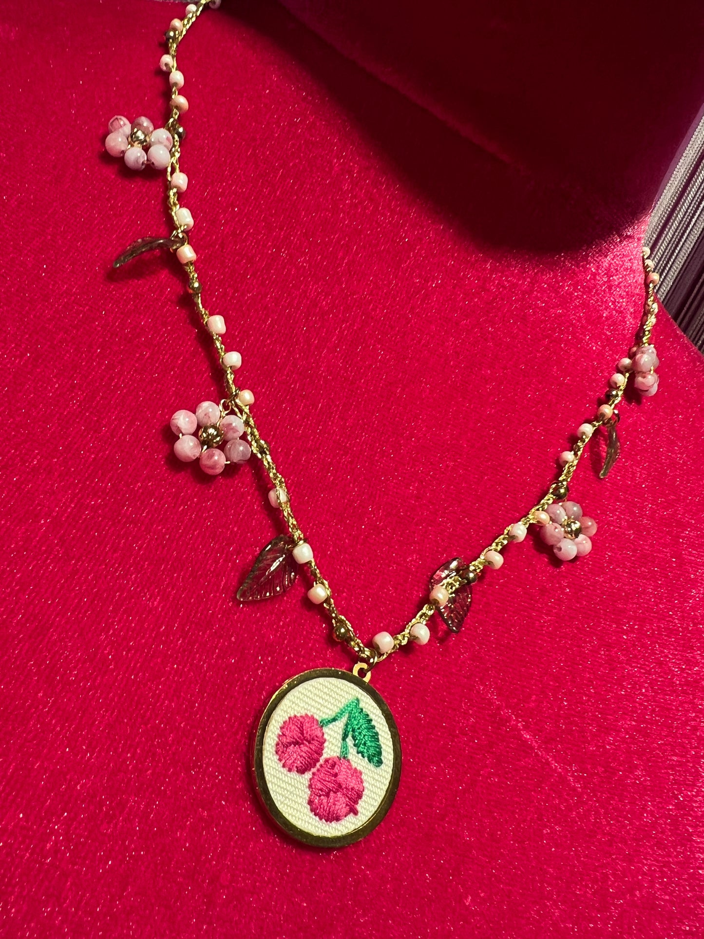 Collana girocollo con filo lavorato all’uncinetto,fiori di perline e ciondolo ciliegie ricamate