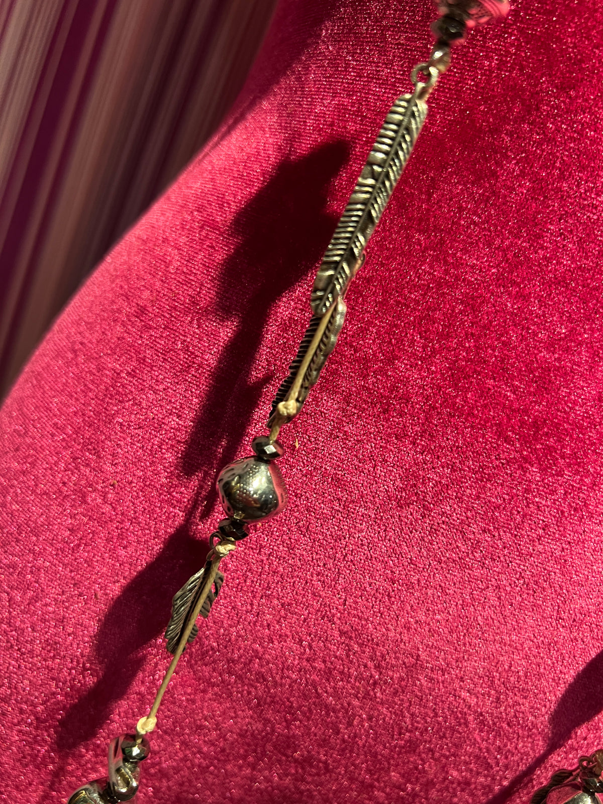 Collana con cordino , elementi color argento e charms piume