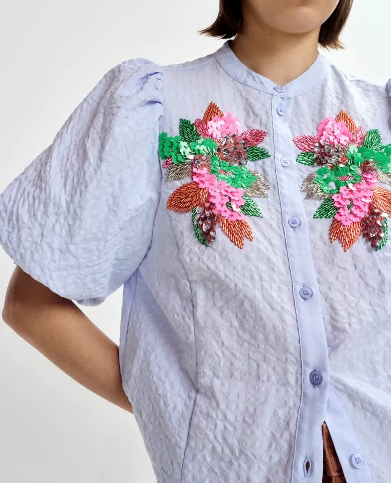 Essentiel antwerp -40% di sconto camicia azzurra manica a sbuffo con motivo floreale impreziosito da paillettes e perline