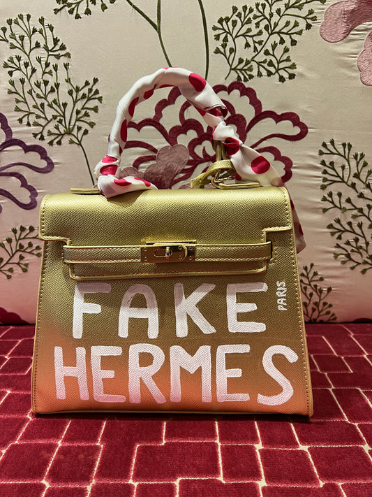 Borsa oro dipinta a mano con scritta  “ Fake Hermes “ bianca con tracollina