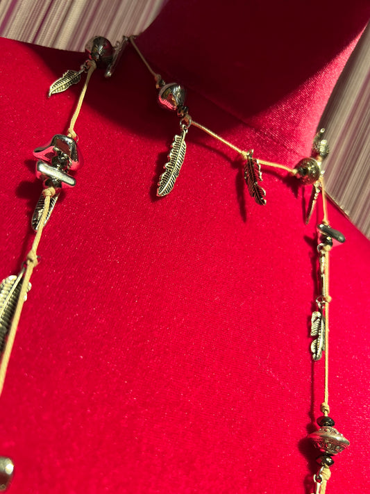 Collana con cordino , elementi color argento e charms piume
