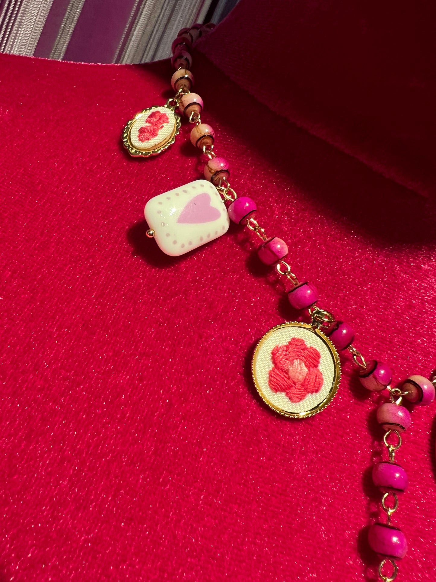 Collana con perline fucsia montatura a rosario con ciondolo fiore ricamato e charms