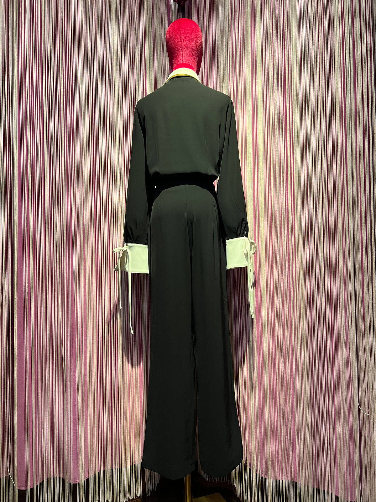 The room jumpsuit nera con colletto e polsi bianchi