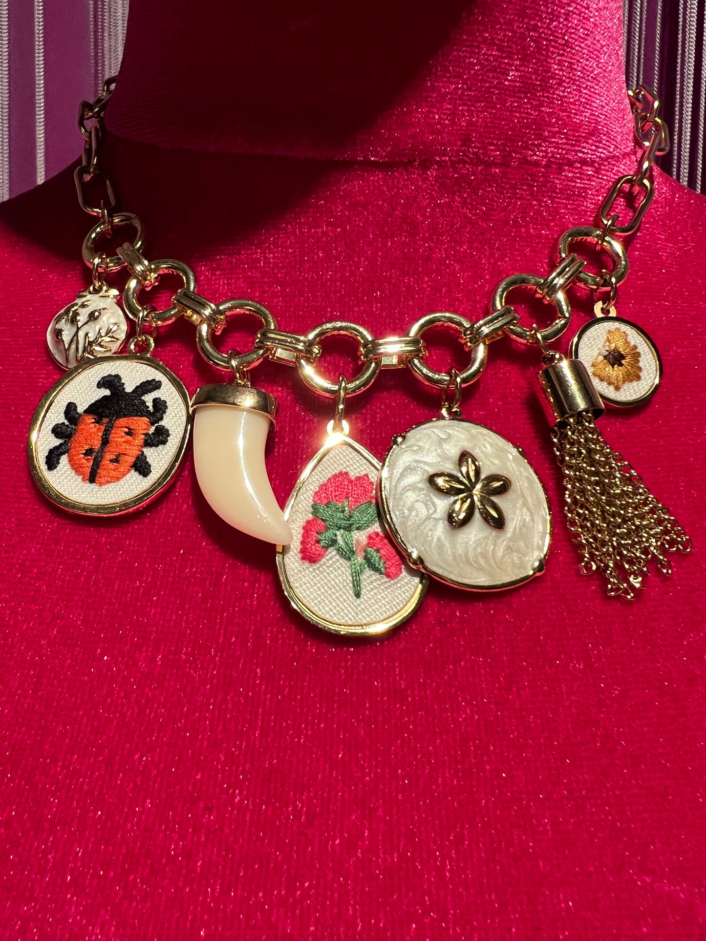 Collana girocollo  catena dorata con charms dorati in tessuto con fiori e coccinelle , corno bianco